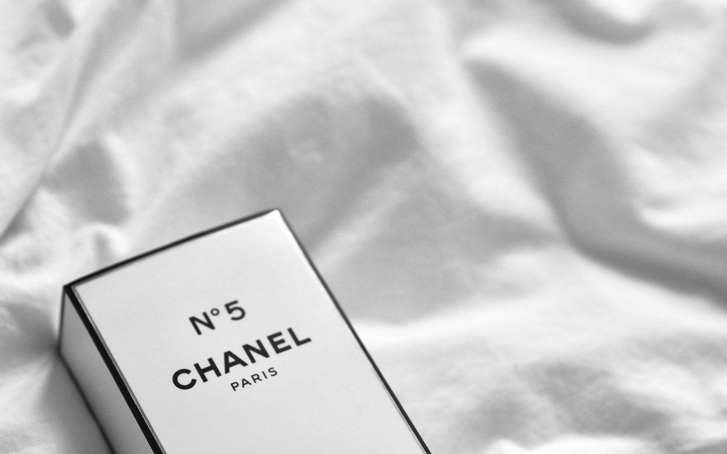 白いシーツの上に置かれた、シャネル N°5の箱