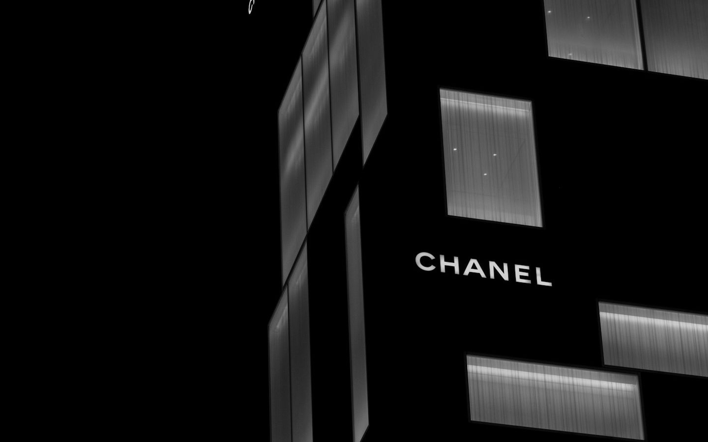 夜の黒い外観に「CHANEL」のロゴが光るシャネルのビル