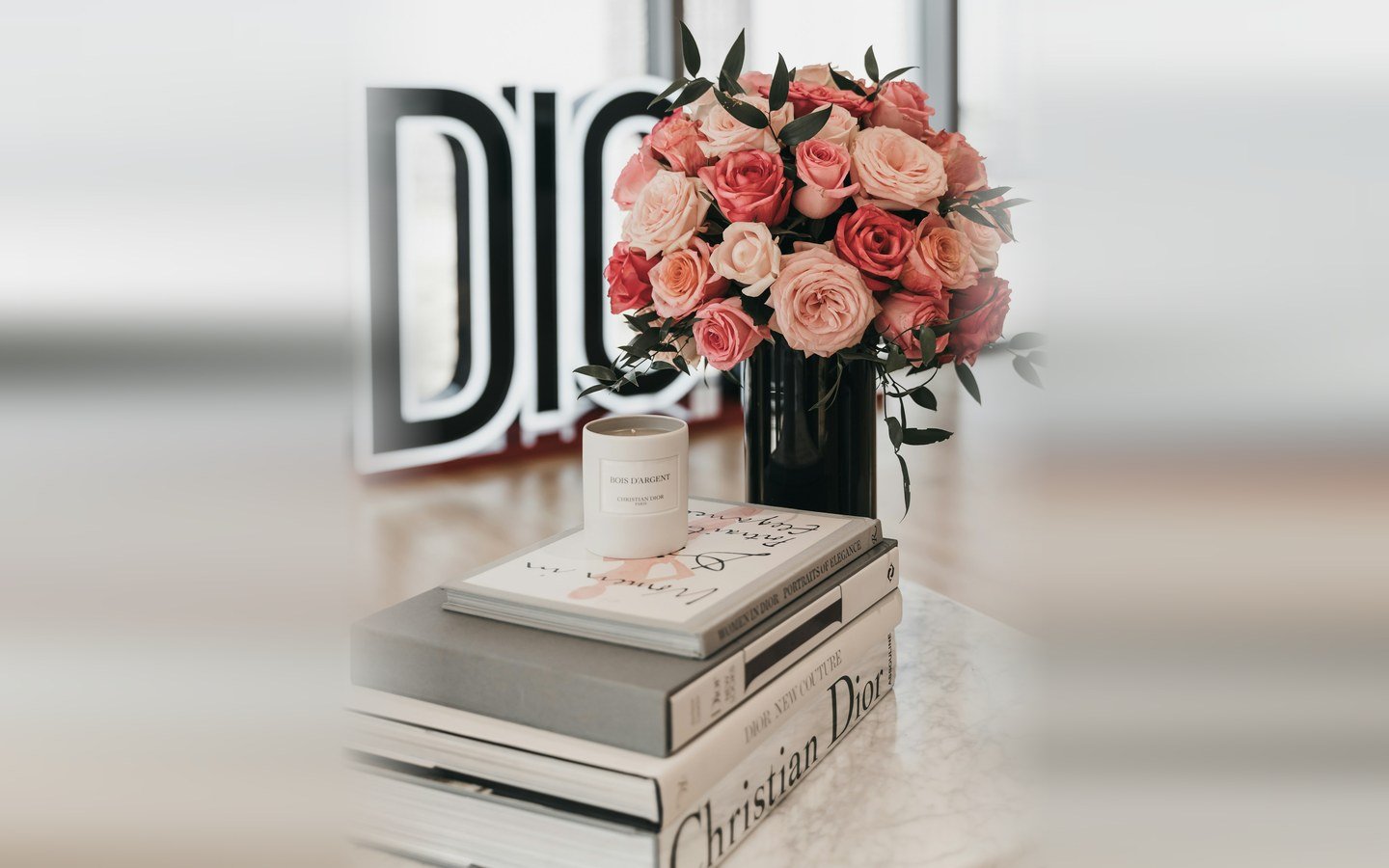 DIORの文字の前に飾られたバラの花束とキャンドル